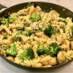 A pan full of cooked chicken & broccoli pasta