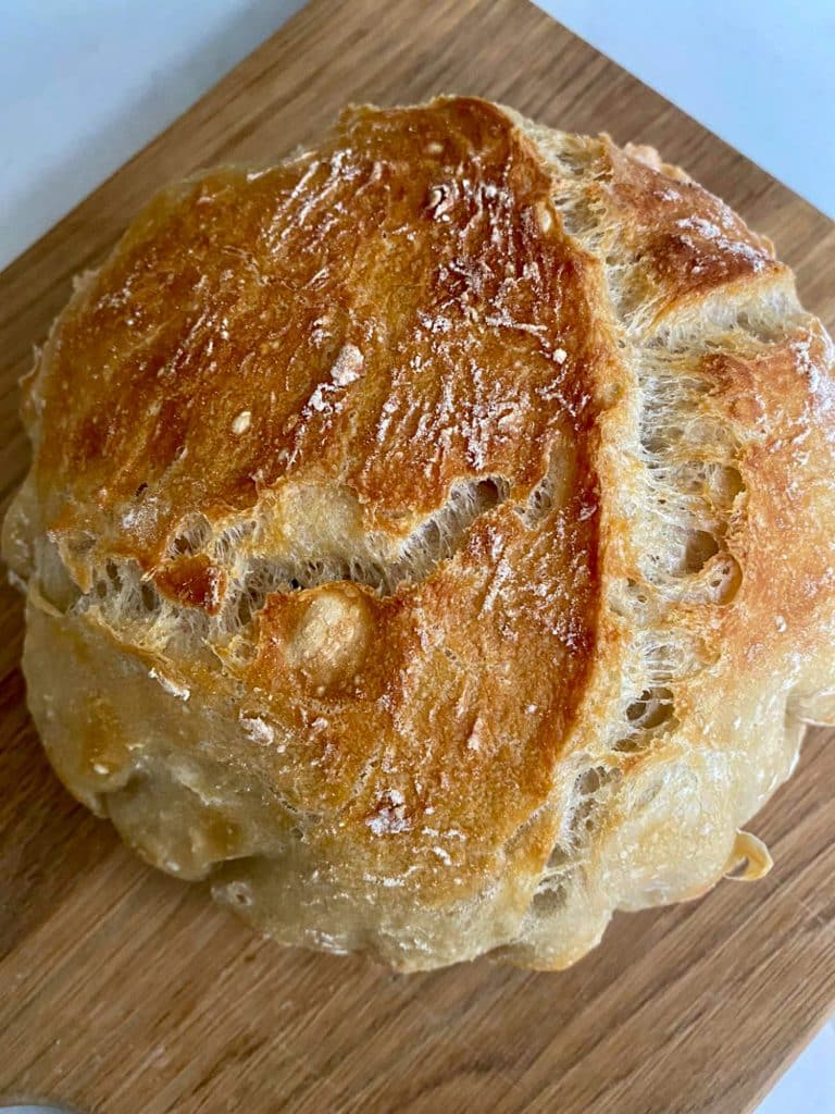 No knead bread full load baked and on a chopping board