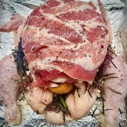 Christmas Chicken ready for the oven covered in streaky bacon