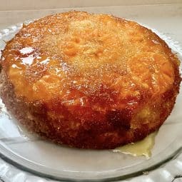 An orange pudding with oranges on top and syrup