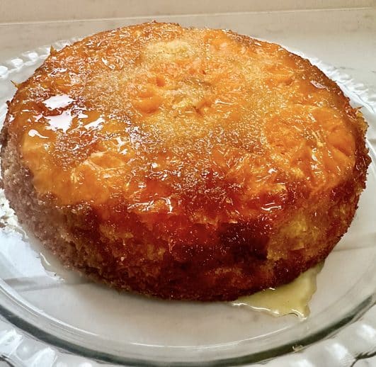An orange pudding with oranges on top and syrup