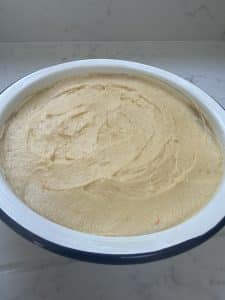 Orange pudding batter unbaked in tin