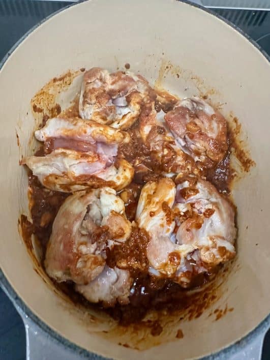 chicken thighs with Thai Red Curry paste in pan