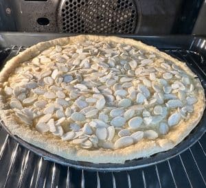 a Bakewell tart into the oven unbaked