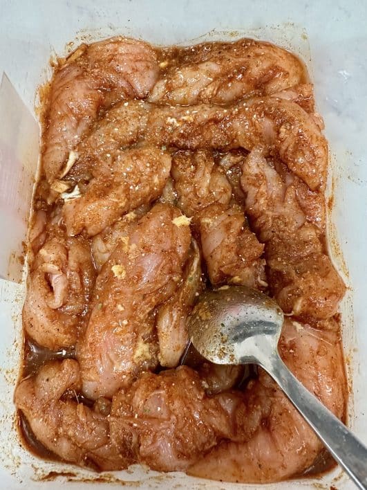 Plastic box with raw chicken in marinade 