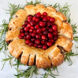 sausage roll in a treat decorated with cranberries and rosemary