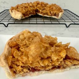 A cornflake tart cut with a piece out