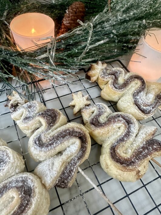 Puff pastry Christmas trees with chocolate spears served on a cooling rack